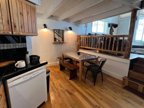 a kitchen with a wooden table and a dining room at Ski In, Ski Out Cozy Creek Side Cabin w Front Yard in Steamboat Springs