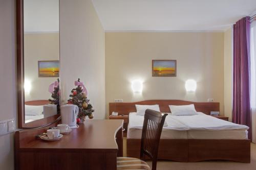 a bedroom with a bed and a table with a christmas tree at Parus Hotel in Lyskovo
