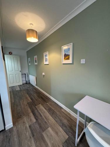 an empty room with green walls and a table at 5b Queens Street, Whitehaven in Whitehaven