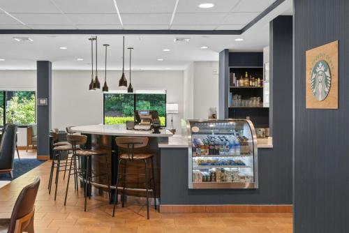 een bar in een restaurant met een tafel en barkrukken bij Courtyard Burlington Williston in Burlington