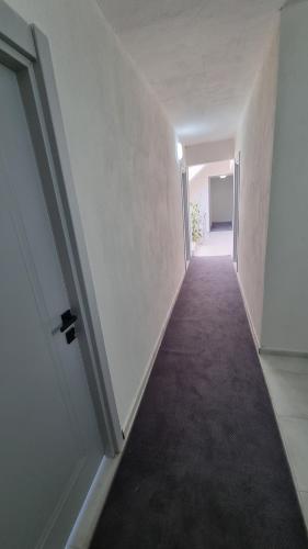 an empty hallway with white walls and an open door at Ugem in Seferihisar