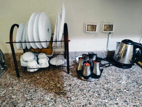 a shelf filled with plates and cups on a counter at Porto Sharm Pool View VIP-Service in Sharm El Sheikh
