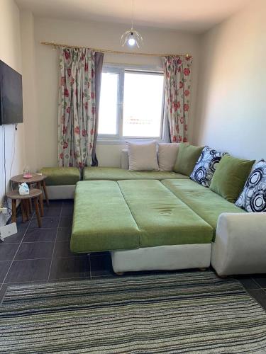 a living room with a green couch in a room at Porto Sharm Pool View VIP-Service in Sharm El Sheikh