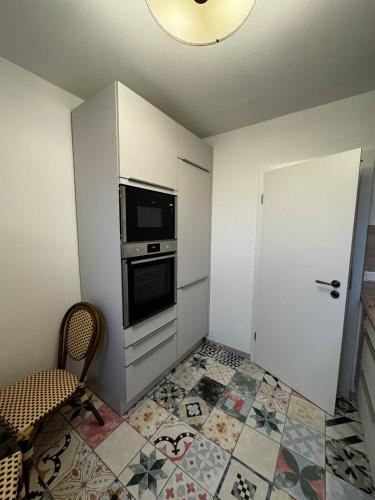 a small kitchen with a stove and a microwave at Paris: Messe-/Business-/FeWo DUS in Hilden
