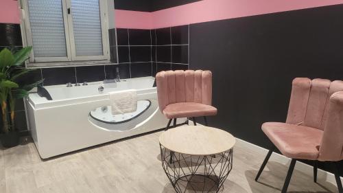 La salle de bains est pourvue de 2 chaises et d'une baignoire. dans l'établissement Point central, à Tourcoing