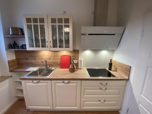 a kitchen with white cabinets and a sink at SYLT: Messe-/Business-/FeWo Düsseldorf in Hilden