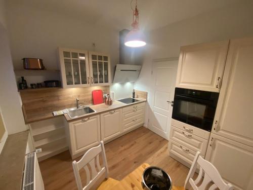 a kitchen with white cabinets and a sink and a stove at SYLT: Messe-/Business-/FeWo Düsseldorf in Hilden