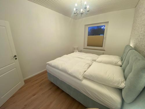 a bedroom with a bed with a couch and a window at SYLT: Messe-/Business-/FeWo Düsseldorf in Hilden