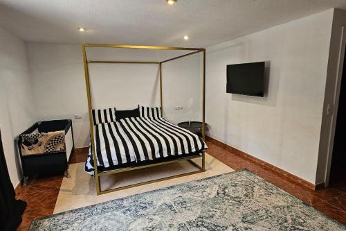 a room with a bed and a tv on a wall at Apartment in big house with private pool & large outdoor space in L'Alfas del Pi