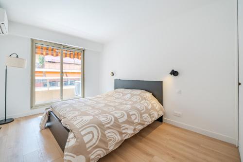 un lit dans une chambre avec une grande fenêtre dans l'établissement Near old town and apartment fully renovated, à Nice