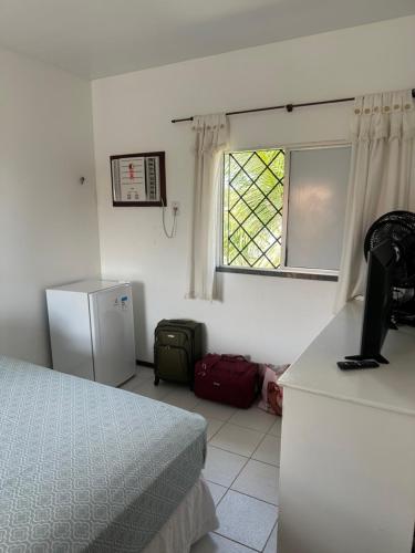 a bedroom with a bed and a window and a computer at Condominio Sol Poente III em Salinopolis-Pará in Salinópolis