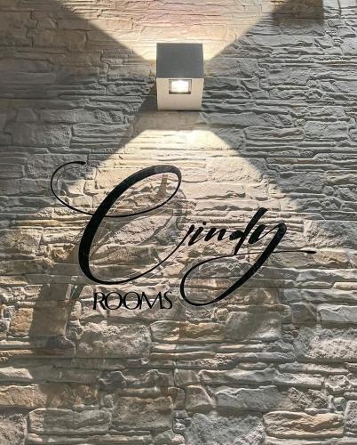 a sign on a stone wall with a laptop on it at Cindy Rooms in Termoli