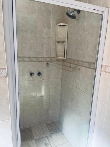a shower with a glass door in a bathroom at Golden Glory Manor in Roodepoort