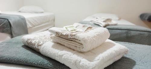 a pile of towels on a table with two beds at Central Park Hotel São Carlos - Fácil Acesso USP e Industrial in São Carlos