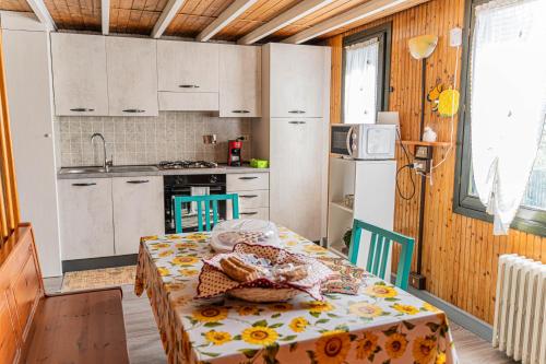 a kitchen with a table and a kitchen with white cabinets at Woodhouse paesana in Paesana