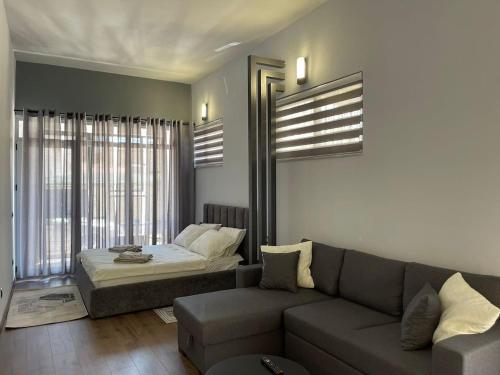 a living room with a couch and a bed at Central Charming Studio Old Town in Durrës