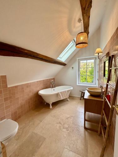 une salle de bain avec baignoire et toilettes et une fenêtre dans l'établissement Maison de campagne proche de Paris, à Vienne-en-Arthies