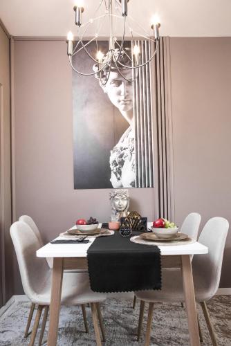 a dining room with a table with a chandelier at Rome Stylish apt w Working Space and Paid Parking Spot in Sofia