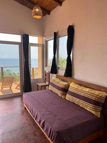 a bedroom with a bed with a view of the ocean at Cabana Alegria - Ocean View Home - 2 Master Suites in San Agustinillo
