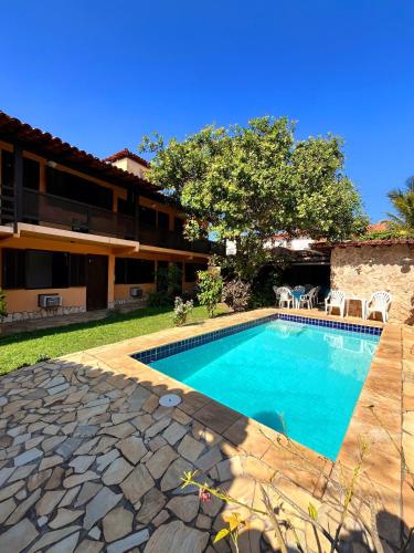 a swimming pool in front of a building at Calmaria Suítes Búzios in Búzios