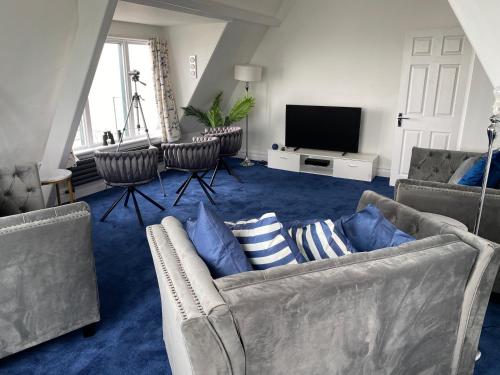 a living room with two couches and a television at Blue Ocean Seaview Penthouse Perfectly Saltburn in Saltburn-by-the-Sea