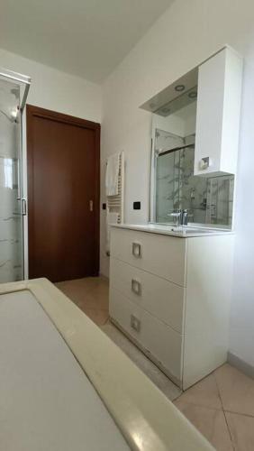 a white kitchen with a sink and a mirror at Aeroporto & Fiera 30 in Seriate