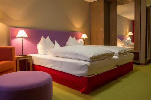 A bed or beds in a room at Schurwald Hotel