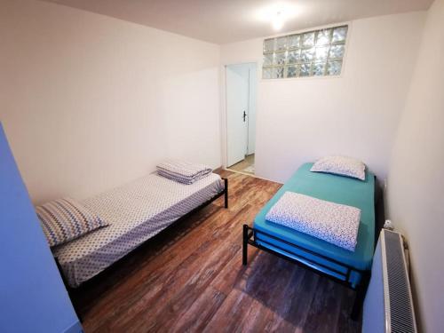 deux lits dans une chambre avec parquet dans l'établissement Centre-ville Sevran f3, à Sevran
