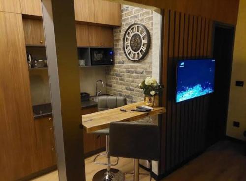 a kitchen with a desk and a clock on a wall at Apartment Despot in Belgrade