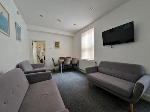 a living room with couches and a flat screen tv at Town centre, very convenient in Newcastle under Lyme