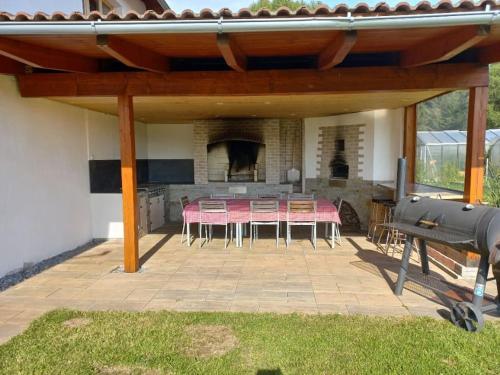 a patio with a table and chairs and a fireplace at Můj malý svět in Černá v Pošumaví