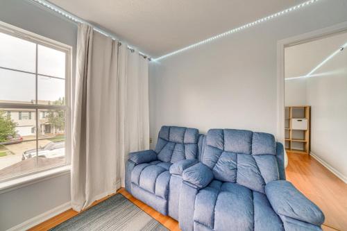 a blue couch in a living room with a window at Louisville Home with Large Yard 15 Mi to Downtown! in Louisville