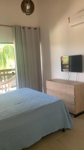 a bedroom with a bed and a flat screen tv at Reserva Eco Itacimirim in Camaçari