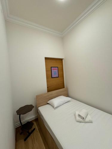 a small bedroom with a bed and a stool at Velvet Vouge Hostel in Yerevan