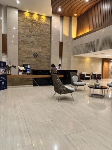 eine Person, die auf einem Stuhl in einer Lobby sitzt in der Unterkunft Aiya's Cozy Staycation in Tagaytay SMDC Wind in Tagaytay