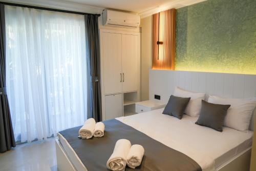 a bedroom with a large bed with slippers on it at Akpınar Marin Hotel in Çeşme