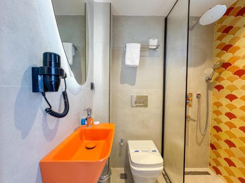 a bathroom with an orange sink and a toilet at Akpınar Marin Hotel in Çeşme