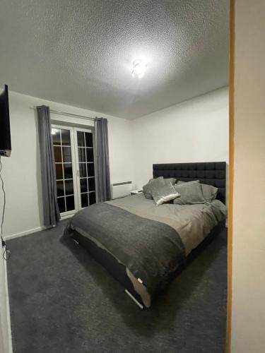 a bedroom with a bed in a room with a window at Cardiff bay apartment with parking in Cardiff