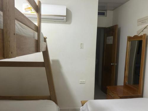 a bedroom with two bunk beds and a mirror at Casa hotel Al Barsha in Necoclí