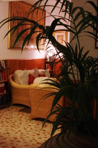 a living room with a couch and a potted plant at Hotel Villa Orio & Beatrice in Venice-Lido