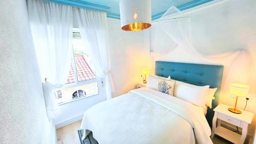 a bedroom with a bed with a blue headboard and a window at Royal Oropesa in Oropesa del Mar