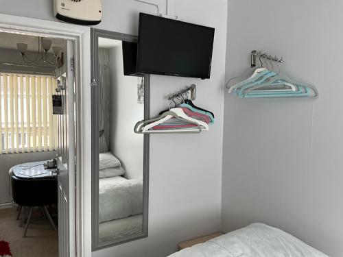 a bedroom with a mirror and a tv and towels at 1st Floor Hillview 2 bedroomed Central Location No pets in Brean