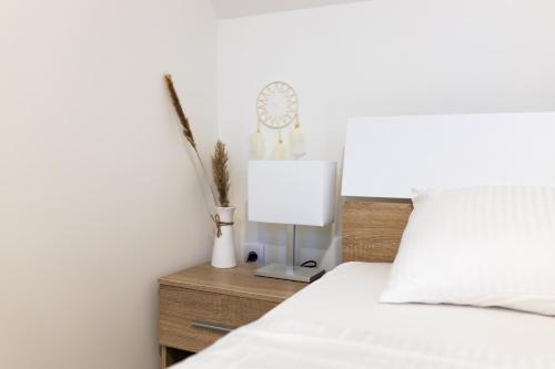 a bedroom with a bed with a lamp and a clock at Villa Ring Pool & Padel Belgrade in Barič