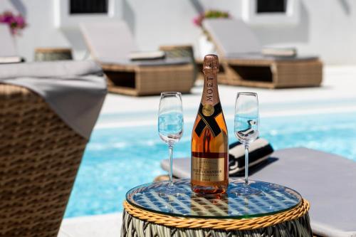 a bottle of champagne and two wine glasses on a table at Villa Ring Pool & Padel Belgrade in Barič