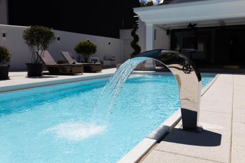 a water fountain in a swimming pool at Villa Ring Pool & Padel Belgrade in Barič