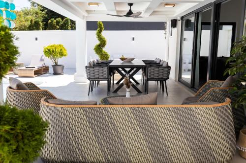 an outdoor patio with a table and chairs at Villa Ring Pool & Padel Belgrade in Barič