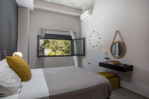 ein Schlafzimmer mit einem Bett mit gelbem Kissen und einem Fenster in der Unterkunft Evie's Oasis in Ixia