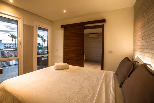 a bedroom with a large white bed and a window at Hotel Tango Suítes Cumbuco in Cumbuco