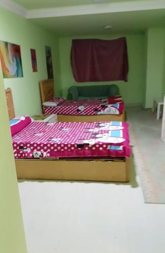 two beds in a room with avertisement at لم تعد الشقه متوفره برجاء عدم الحجز لا استطيع ازاله الاعلان او التواصل مع الدعم in Mansoura