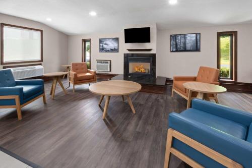 a waiting room with chairs and tables and a fireplace at Super 8 by Wyndham Bridgeport/Clarksburg Area in Bridgeport